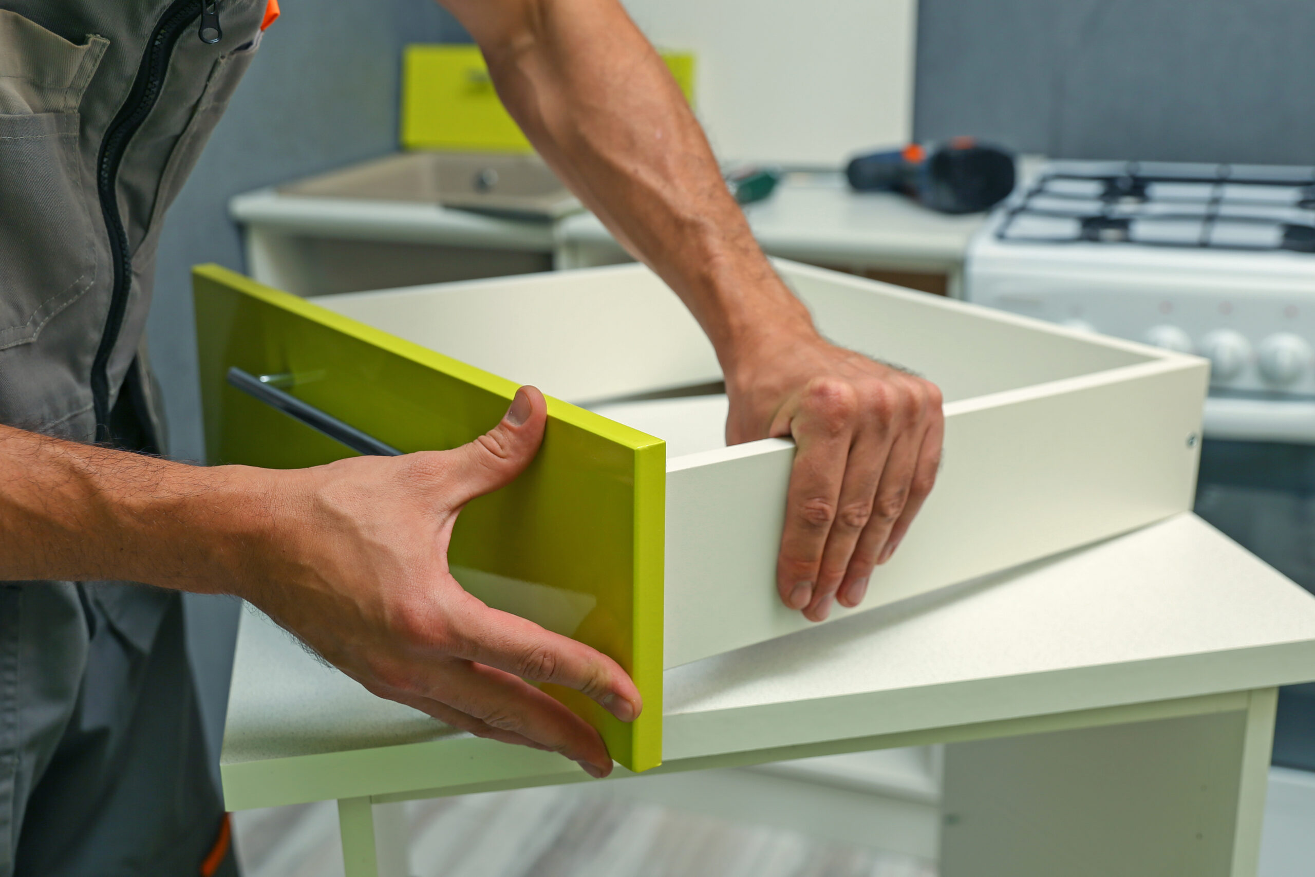 Worker Assembles Furniture In The Kitchen. Furniture Assembly Service
